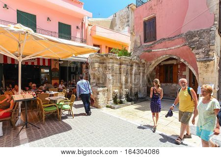 Rethymnon, Island Crete, Greece - July 1 2016: People are eating in cafe located near the Rimondi Fountain in Rethymnon (part of Old Town). The Rimondi fountain was built in 1626 by the city's Rector A. Rimondi.