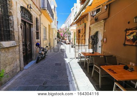 Rethymnon, Island Crete, Greece - July 1 2016: The narrow street of Rethymnon (part of Old Town) where there are a lot of small cafes and shops
