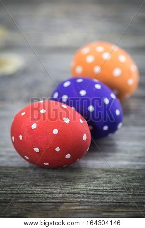 Easter egg colored polka dots lie on wooden background