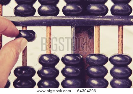 close up image of hand accounting with old abacus. financial concept