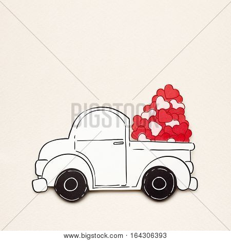 Creative valentines concept photo of paper car with hearts on grey background.
