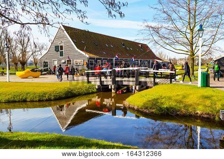 Zaanse schans, Netherlands - April 1, 2016: Wooden shoes, clogs or klompens museum in Holland, people around