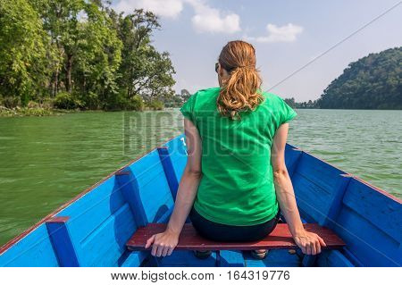 Attractive brunette enjoying boat ride in sunny weather. Lake Phewa, Pokhara in Nepal.