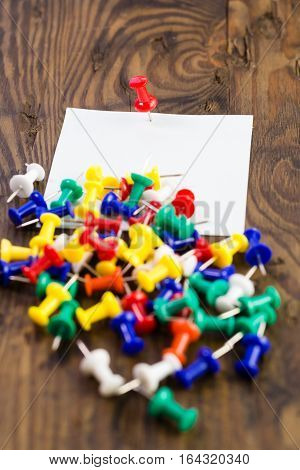 Various Color Thumbtacks And Note On Distressed Wood