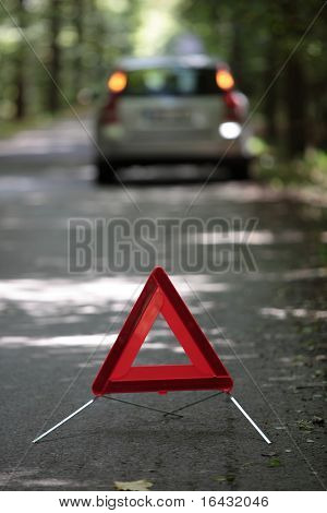 descompone el coche con triangulo detrás de ella esperando ayuda llegar (profundidad de f