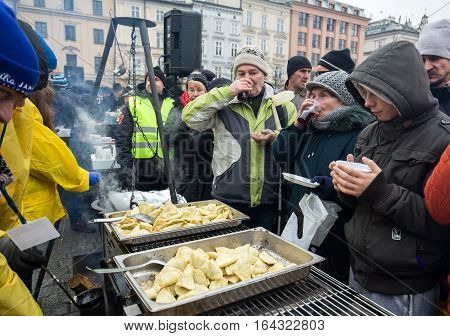 CRACOW POLAND - DECEMBER 18 2016: Christmas Eve for poor and homeless on the Central Market in Cracow. Every year the group Kosciuszko prepares the greatest eve in the open air in Poland