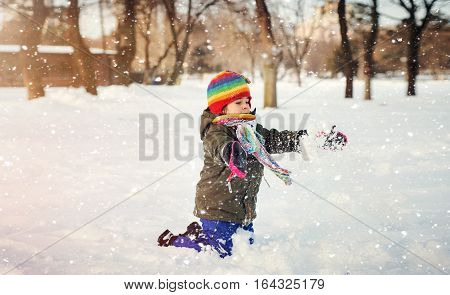 A child is playing with the snow