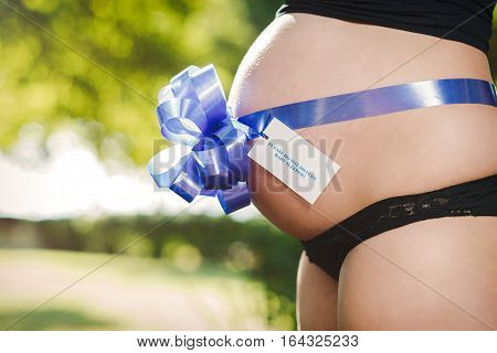 Pregnant woman with a sign on her belly