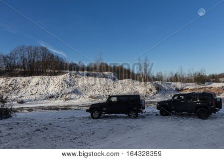 The river Tosno, Leningrad oblast, Russia - January 07, 2017, Hammer H3 and Jeep Wrangler Jk on the shore of the river, the Hummer H3 is a compact SUV produced by GM