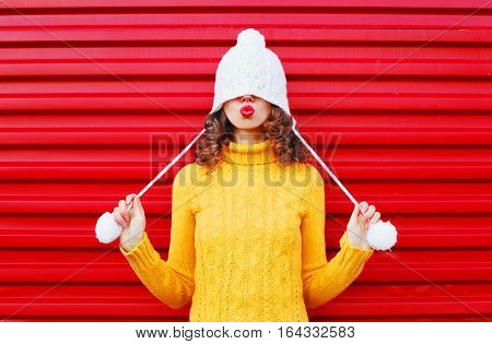 Fashion Happy Woman Blowing Red Lips Makes Air Kiss Wearing Colorful Knitted Hat, Yellow Sweater Ove