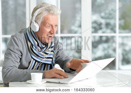 Portrait of a man listening to music, using laptop