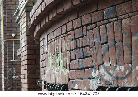 a semi-circular wall of red bricks with painted