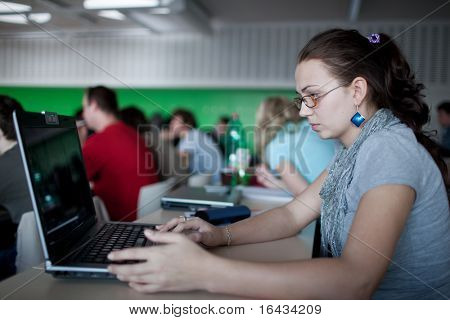 jeune étudiante jolie femelle assis dans une salle de classe pleine d'élèves au cours de la classe