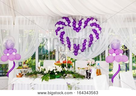 beautiful wedding decorations. Heart of white and purple balloons on a celebratory table