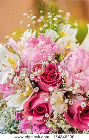 Close up wedding rings at a flower bouquet