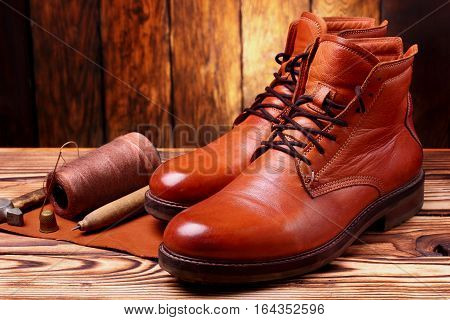 Leather Boots And Bootmaker Tools Awl, Nails, Skien Of Thread .wooden Background.concept Tools Bootm