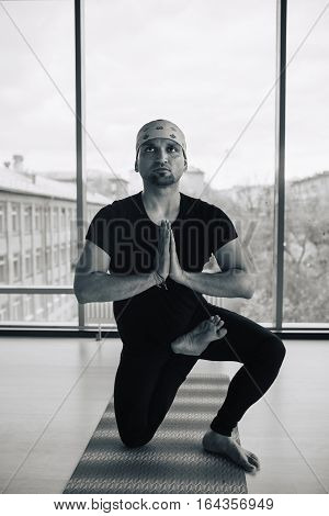 Young handsome man doing yoga meditation indoors.