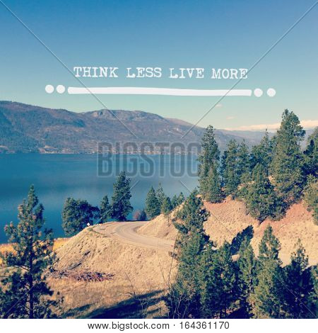 Scenic summer lake landscape with mountain road and tall trees in foreground.  Lake, clear blue sky and mountains in background with inspirational quote. 