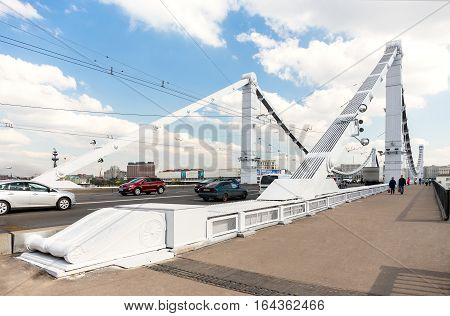 MOSCOW - SEPTEMBER 14 2015: People and cars on Krymsky (Crimean) Bridge. It spans the Moskva River and carries the Garden Ring across the river.