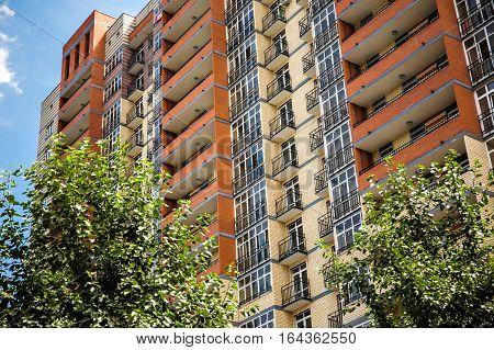 New modern multistorey apartment building with tree on the foreground