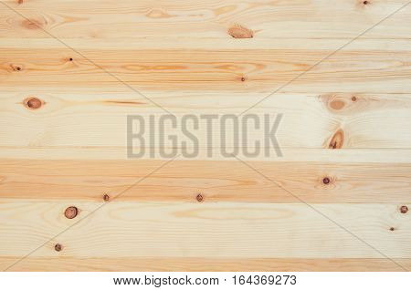 Fresh knotted pine wood planks background top view. Visible texture with natural patterns.