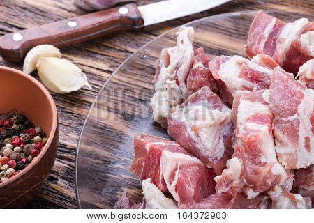 diced bacon raw meat in a plate on a wooden board