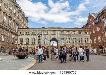Copenhagen, Denmark, July 20, 2016, Asian tourists standing in front of  the Danish Parliament. They take part in a  guided tour.
