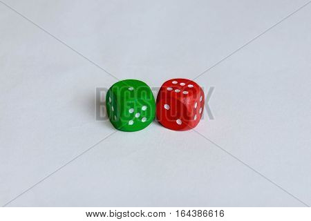 A green and a red colored are isolated. The red one is showing six pips and the green one only one.
