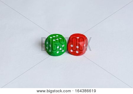 A green and a red colored are isolated. The green one is showing six pips and the red one only one.