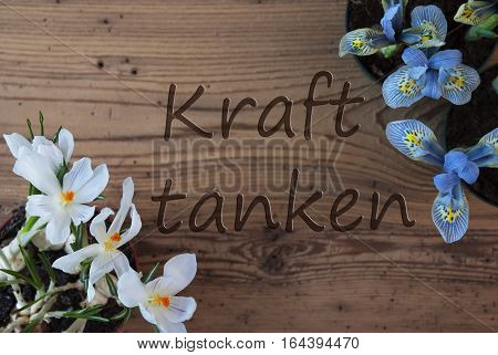 Wooden Background With German Text Kraft Tanken Means Relax. Spring Flowers Like Grape Hyacinth And Crocus. Aged Or Vintage Style