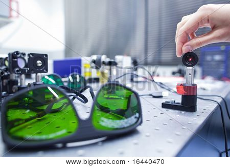 cientista fêmea fazendo pesquisas em um laboratório de óptica quântica (imagem de cor em tons)