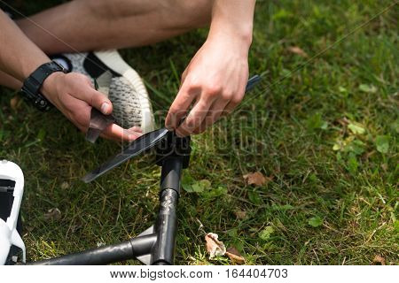 Man Tightening Propeller On Drone In Nature