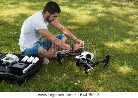 Man Tightening Propeller On Drone In Nature