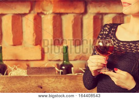 Woman Tasting Wine In Rural Cottage Interior