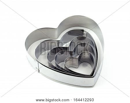 close up many size of silver heart shaped cookies cutter isolated on white background, kitchen tools for preparation valentine snack