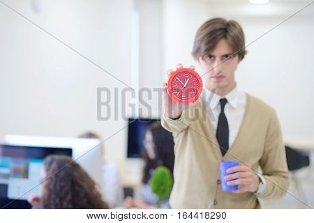young angry businessman pointing his watch as concept of arrive late at the work at modern startup office
