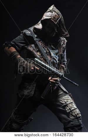 Nuclear post apocalypse life after doomsday concept. Grimy survivor with homemade weapons. Studio closeup portrait on black background