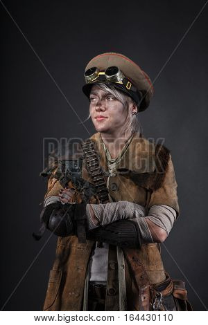 Nuclear post apocalypse life after doomsday concept. Face of grimy female survivor in tatters. Studio closeup portrait on black background