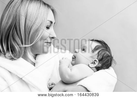 Mother embrace her cute baby boy after bath.