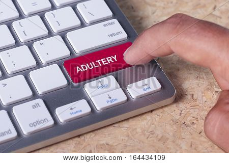 Man pressed keyboard button with adultery word