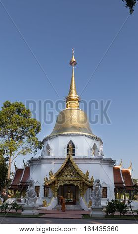 Buddhist Monk Working With Broom Sweeps Floor In Front Of Golden Pagoda