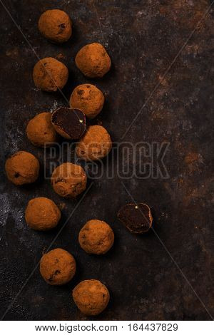 Dark chocolate avocado truffles sprinkled with cocoa on dark rusty metal background. Selective focus