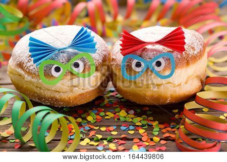 Carnival doughnuts with funny faces and paper streamers