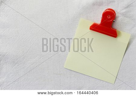 yellow of note paper placed on White fabric backgroundDesign ideas can be Entered your Message into the space as needed.