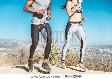 Multi-ethnic couple training in a canyon - Sportive boyfriend and girlfriend running outdoors