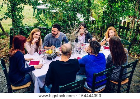 Group of friends at restaurant outdoors - People having dinner in a home garden