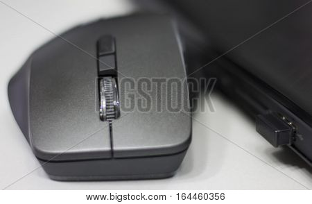Wireless mouse connected to laptop via mini usb dongle.