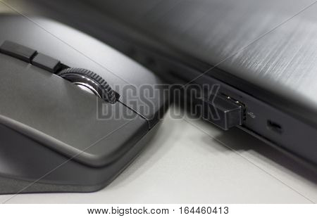 Wireless mouse connected to laptop via mini usb dongle.