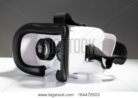 Virtual reality VR glasses or goggles isolated on white background with mirror reflection. Closeup product photograph. Computer simulated reality concept image with copy space 3D