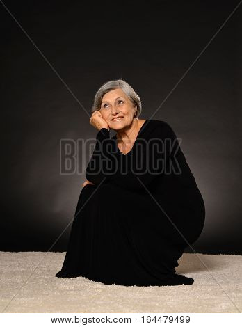 Portrait of a beautiful mature woman, against dark background